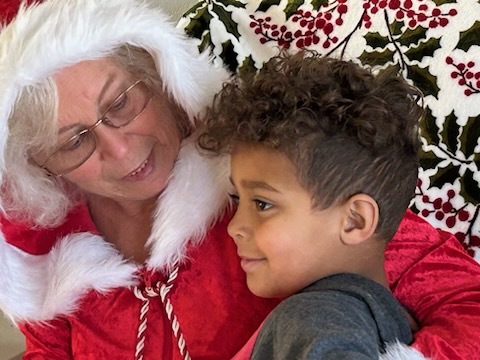 Mrs. Clause and a young boy with curly hair. 