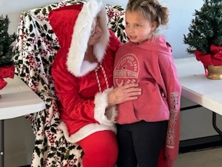 Mrs. Clause talking to a young girl. 
